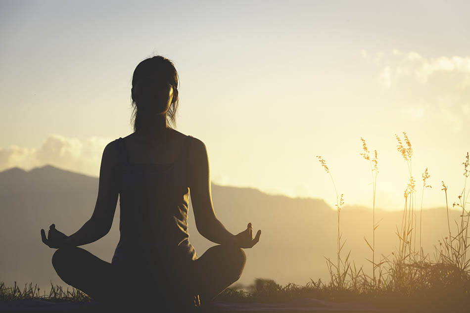 A serene image of a person practicing meditation in a natural setting, symbolizing the integration of traditional healing practices into modern life